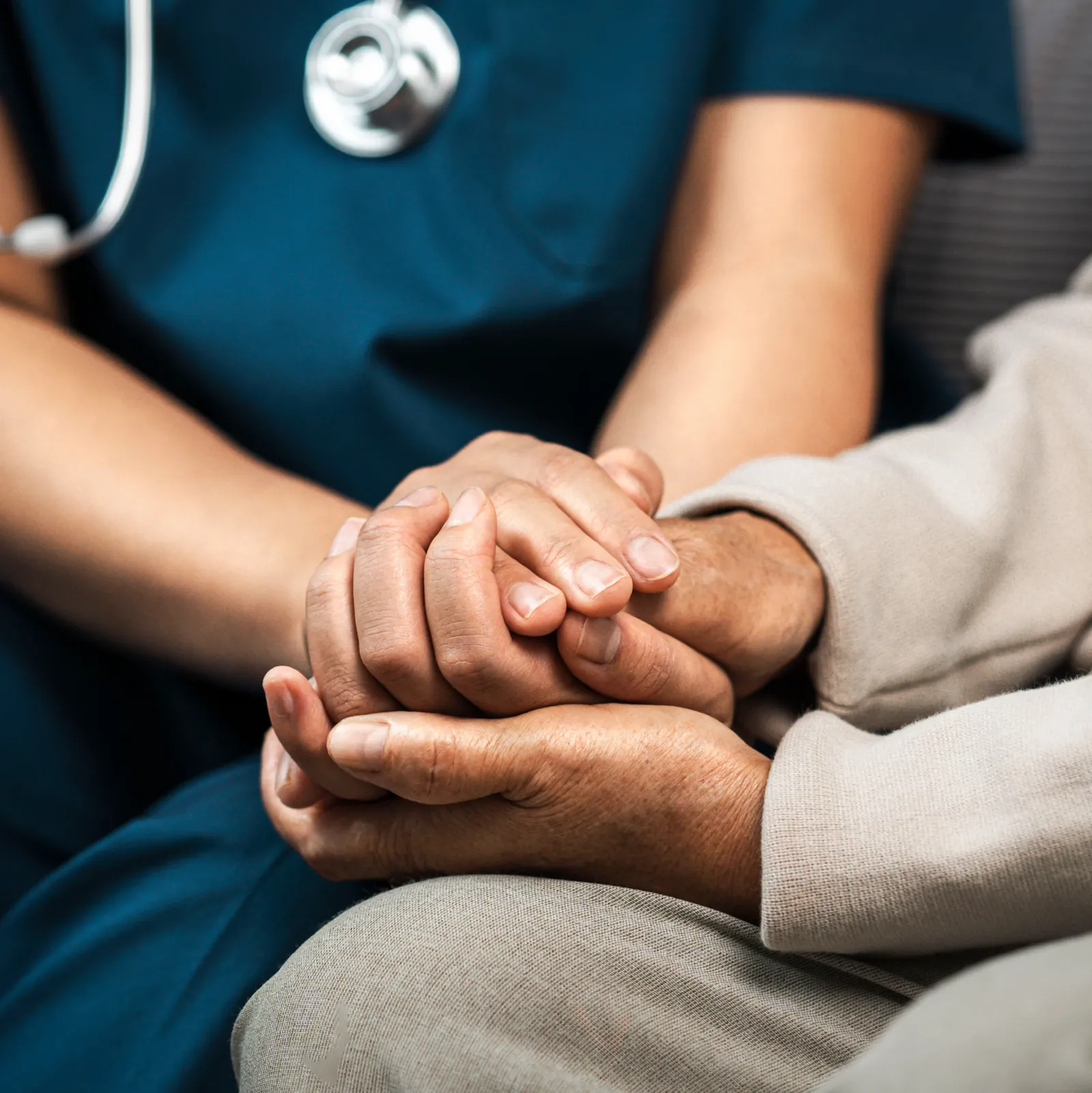 A clinician holding a patient's hands in support
